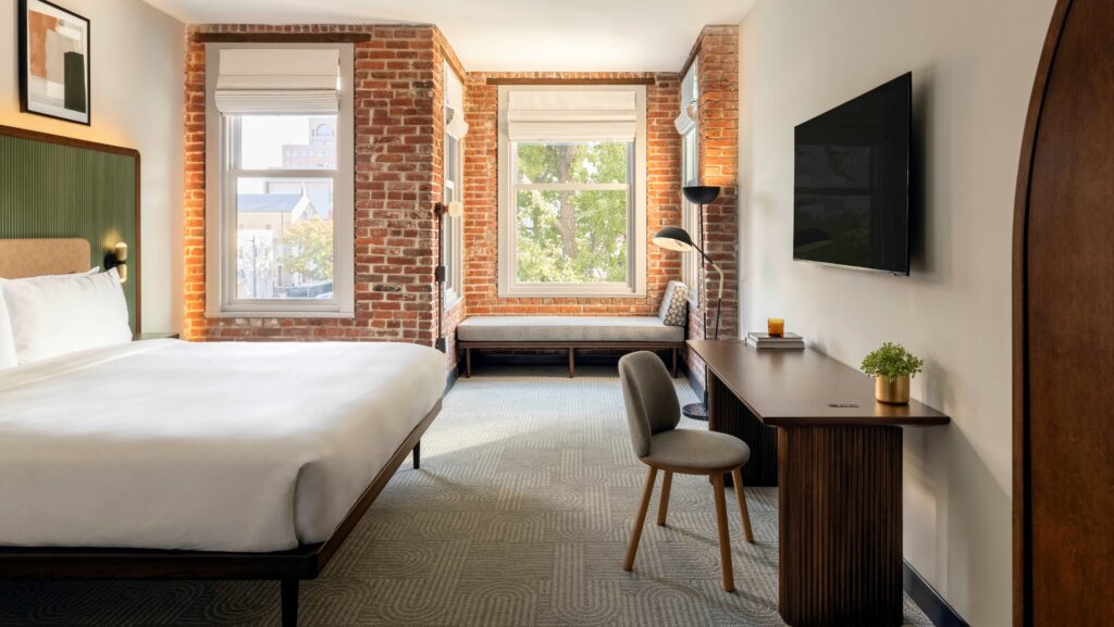 A guest room with exposed brick walls at Arlo Washington DC