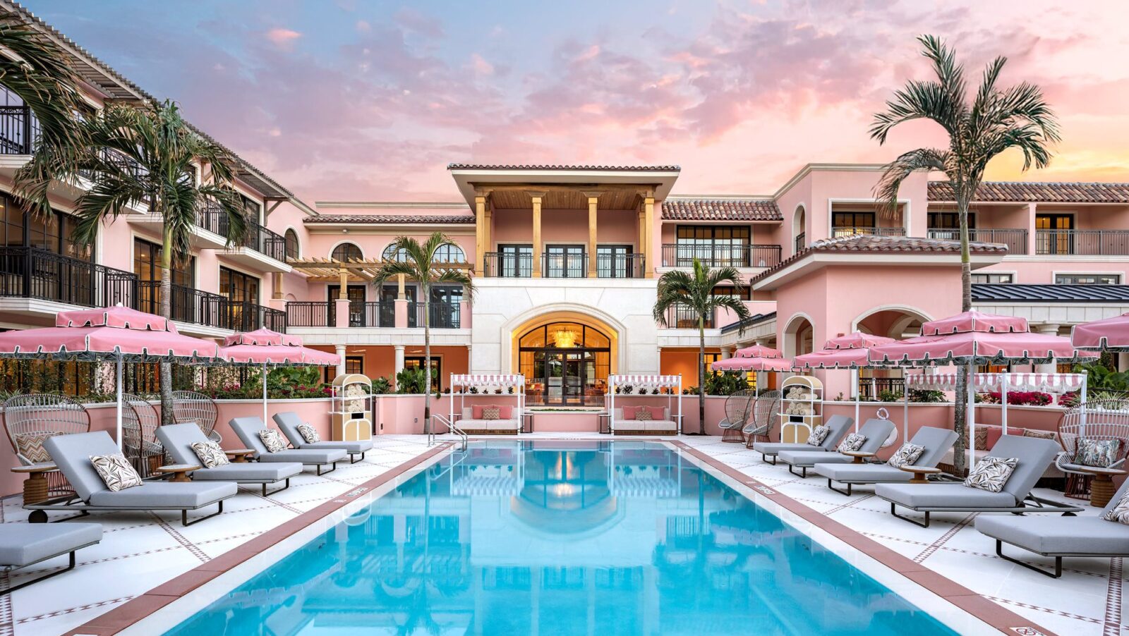 The pink-hued pool area at Palm House at sunset