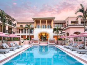 The pink-hued pool area at Palm House at sunset