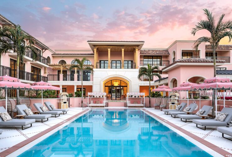 The pink-hued pool area at Palm House at sunset