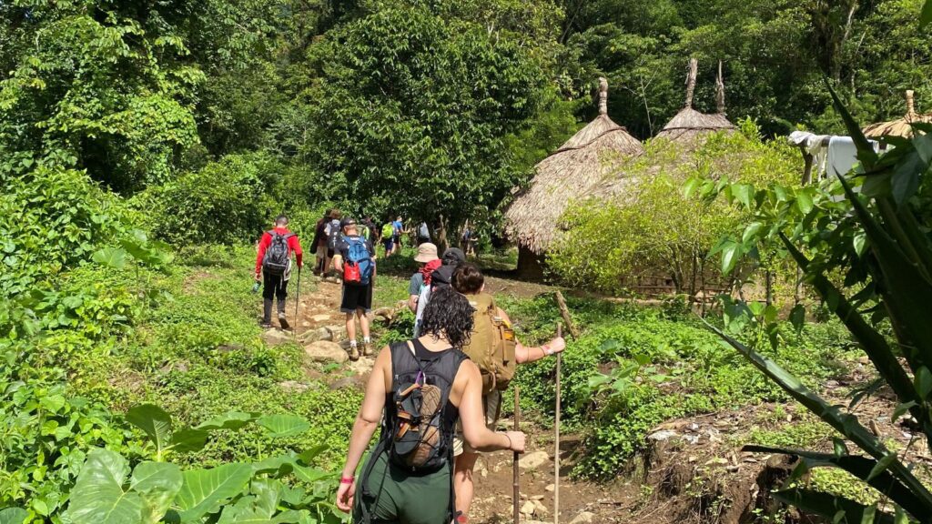 hikers walking through a village on the way to Colombia's Ciudad Perdida