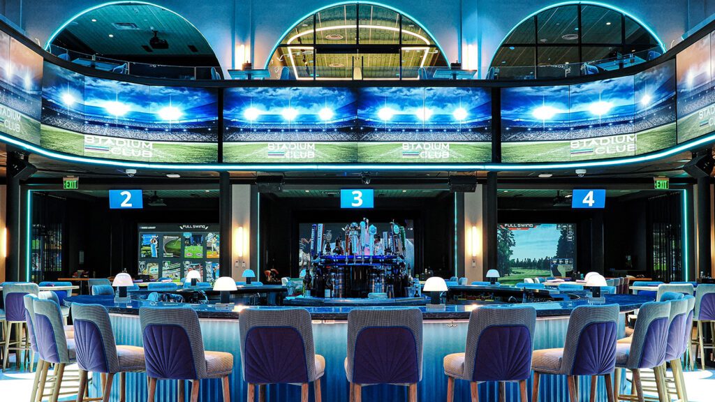 Circular bar surrounded by TV screens and sports simulators