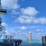 cruise ship and Caribbean waters with lighthouse in the background