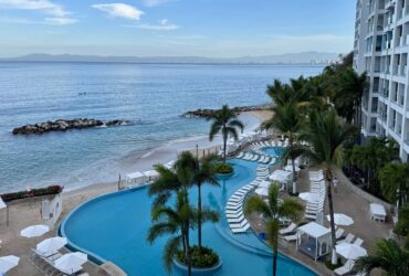 Pool, hotel, and Bay of Banderas view at Hilton Vallarta Riviera all-inclusive resort