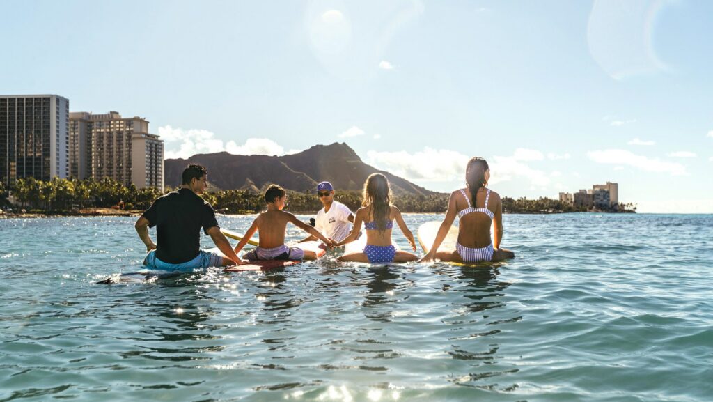 A family taking a surfing lesson at Waikiki Beach on Oahu