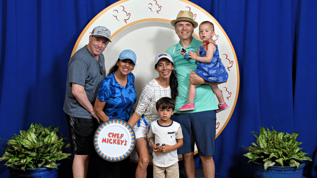 Multigenerational family holding a sign that says Chef Mickey's