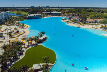 Sprawling lagoon surrounded by grassy lawns, small beaches and buildings