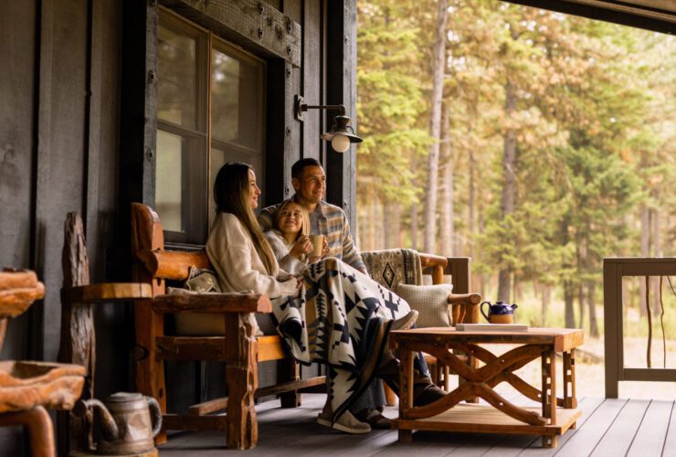 A family shares a moment outside their cabin at Paws Up Montana.