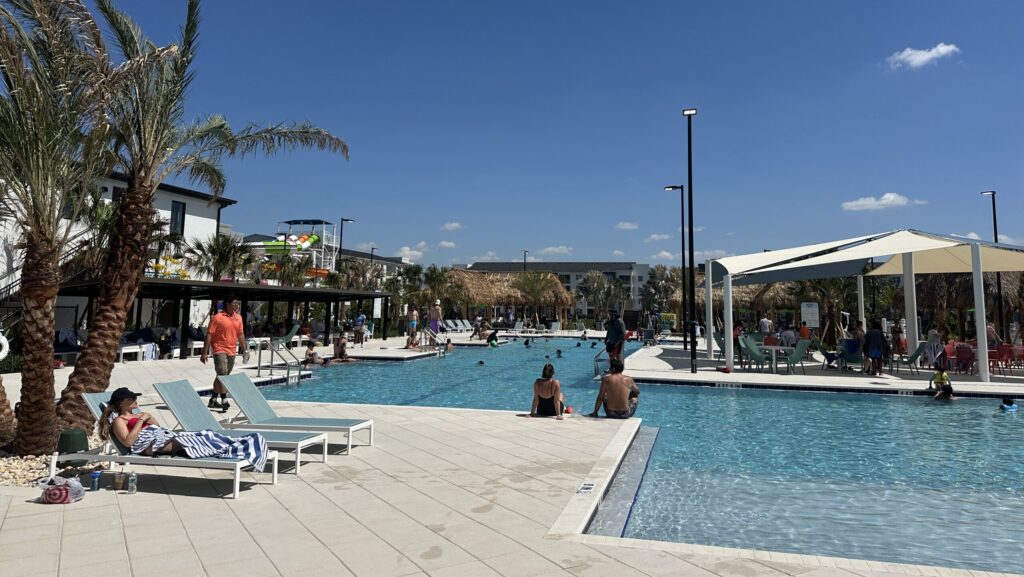 People enjoy the main pool of Villatel Orlando Resort