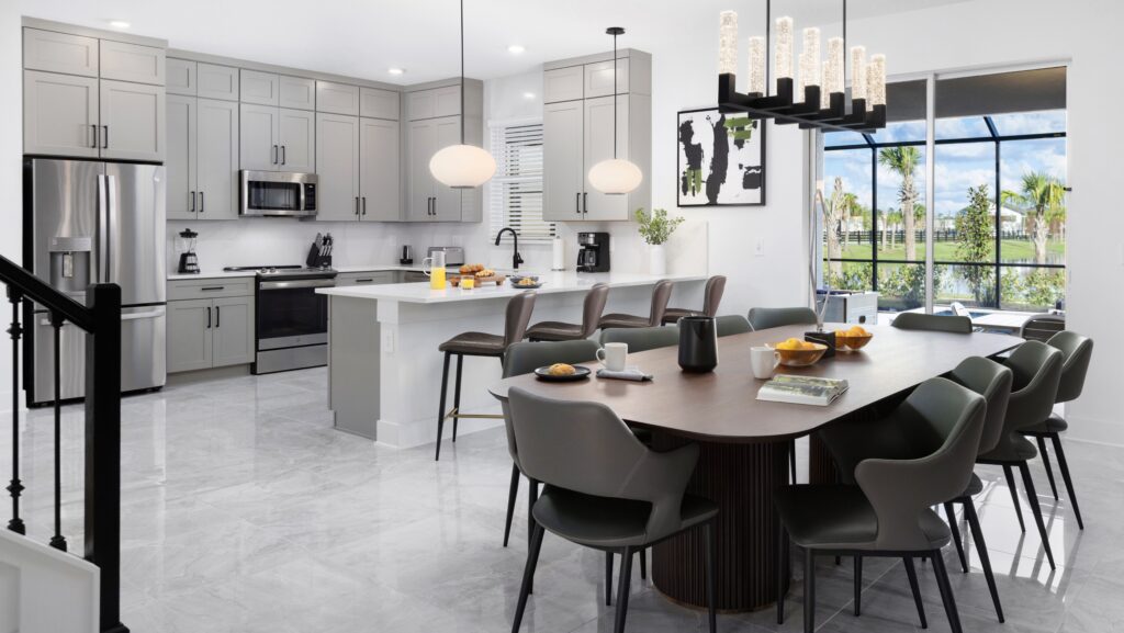 The kitchen and dining room of one of the villas of the Villatel Orlando Resort, with tiles and gray cupboards.