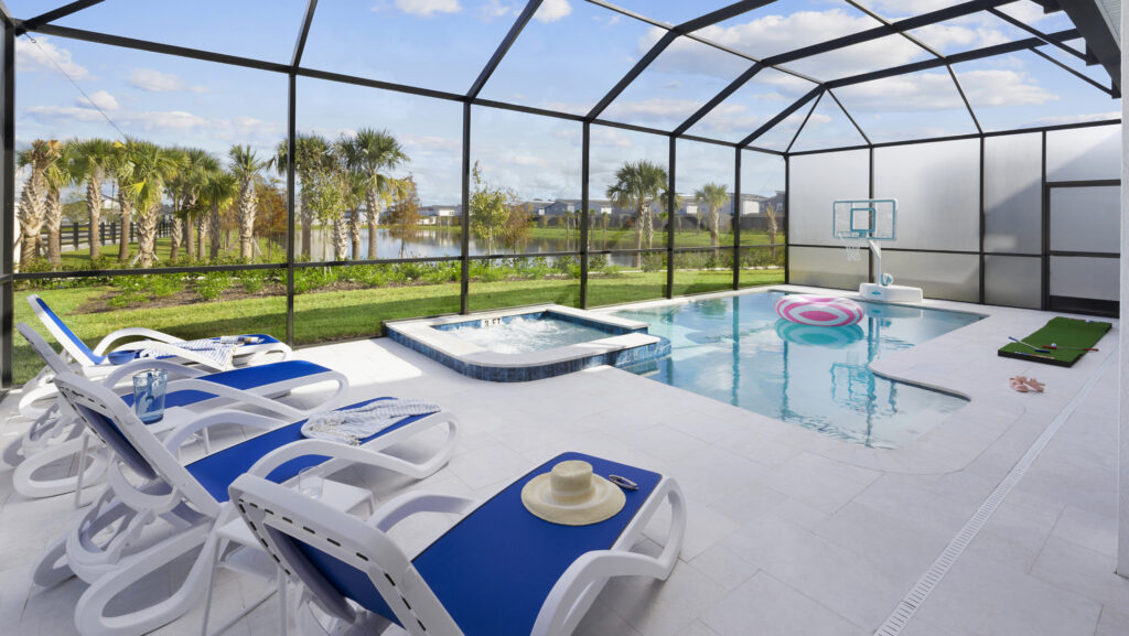 A swimming pool and a spa with lounge chairs, a pink float and a basketball hoop