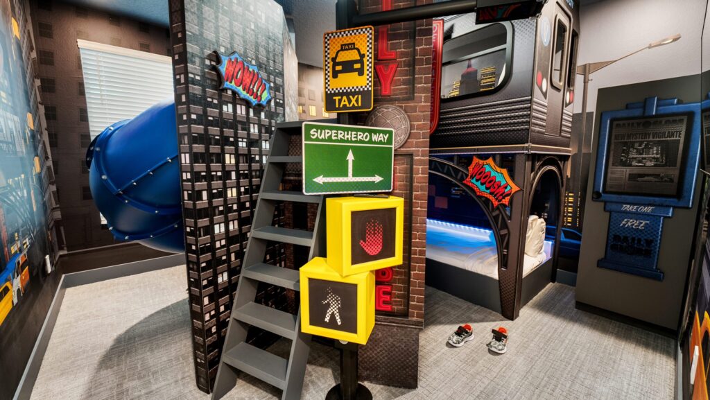 A children's room on the theme of superheroes with a blue twisted slide and fun signaling