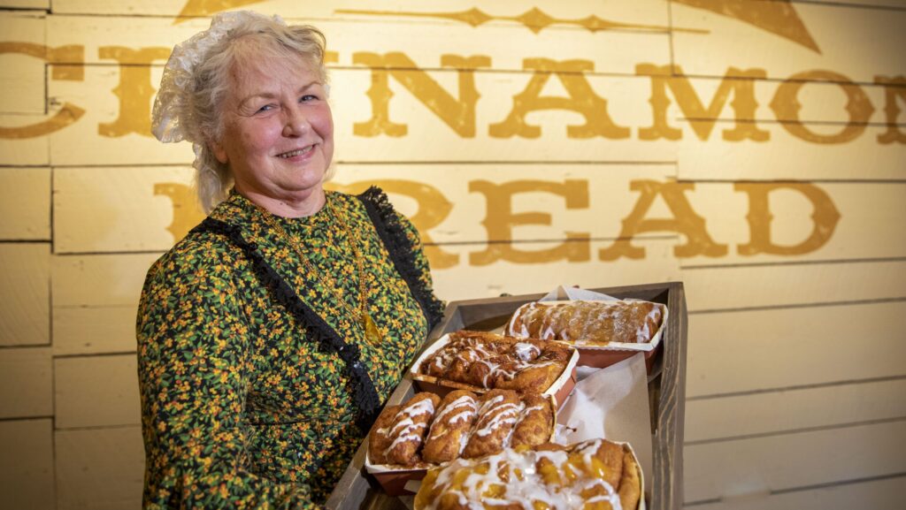 Woman holding a tray of cinnamon bread at Silver Dollar City.