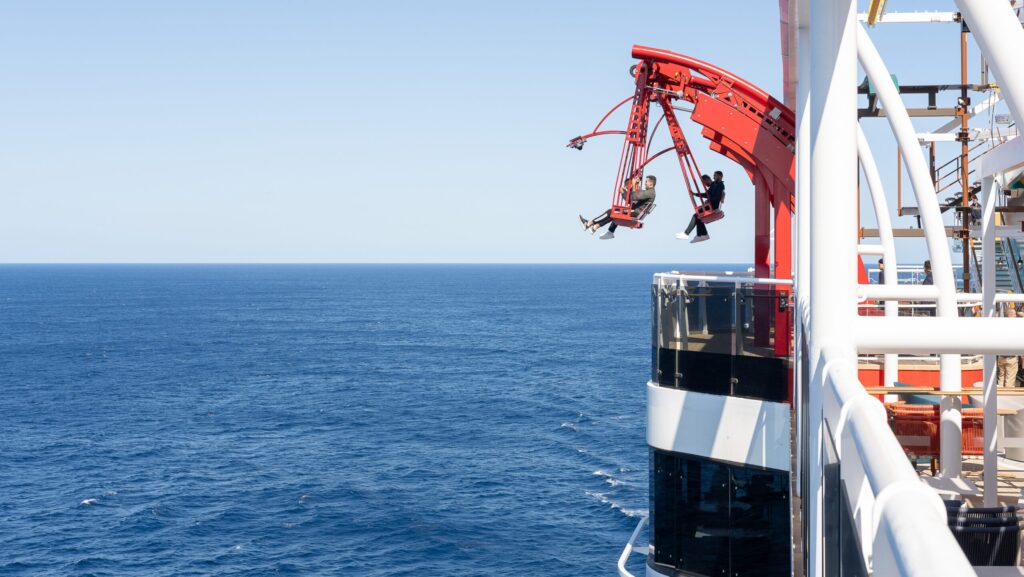 Two red swings hanging over the water on MSC World America