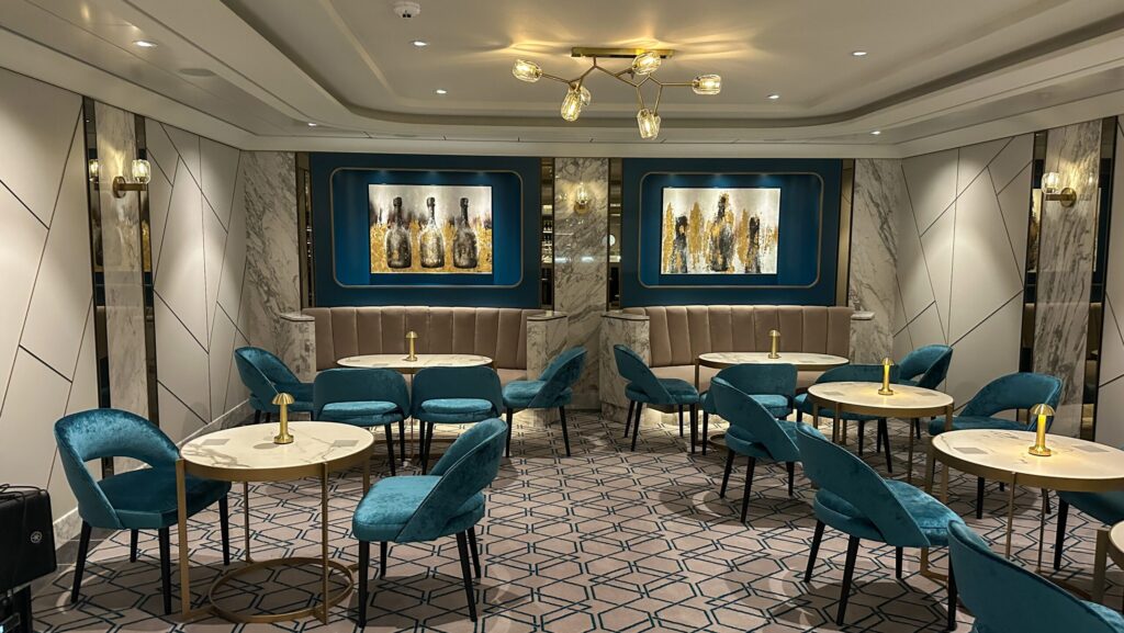 Aqua chairs and gold accents in the seating area at Fizz Champagne Bar on MSC World America