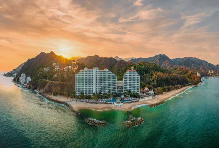 Hotel on mountainous coastline at sunset