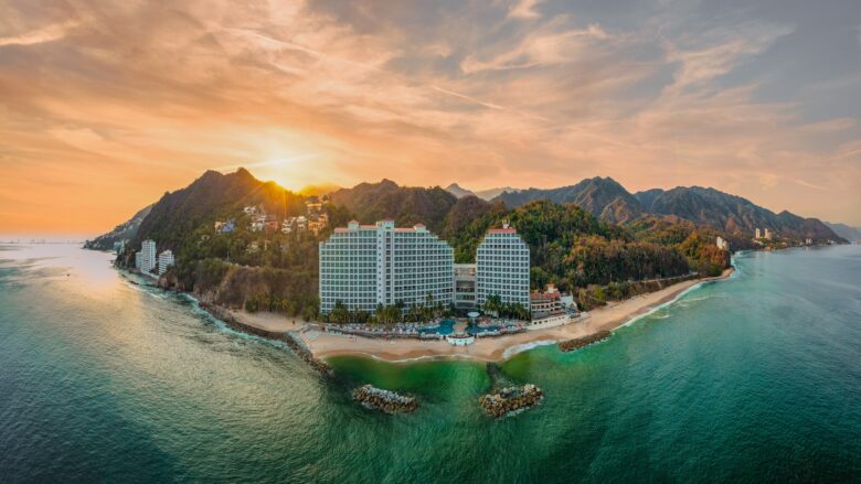 Hotel on mountainous coastline at sunset