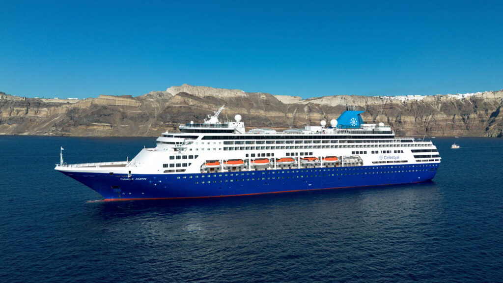 Cruise ship anchored in the Aegean Sea with rugged mountains in the background