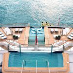 Two swimming pools on decks of cruise ship anchored in ocean