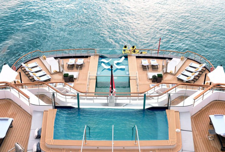 Two swimming pools on decks of cruise ship anchored in ocean