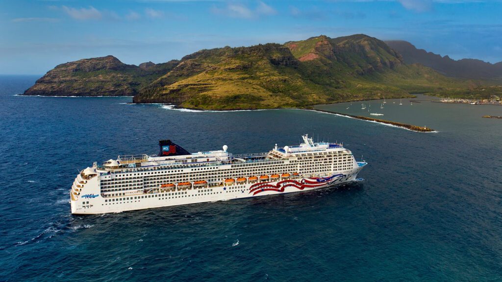 Cruise ship with lush green mountains in the background