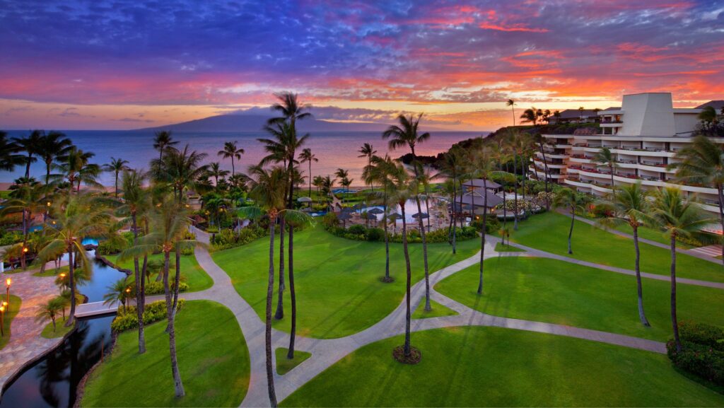 An aerial view of the lawn, pool, and ocean at sunset at Sheraton Maui