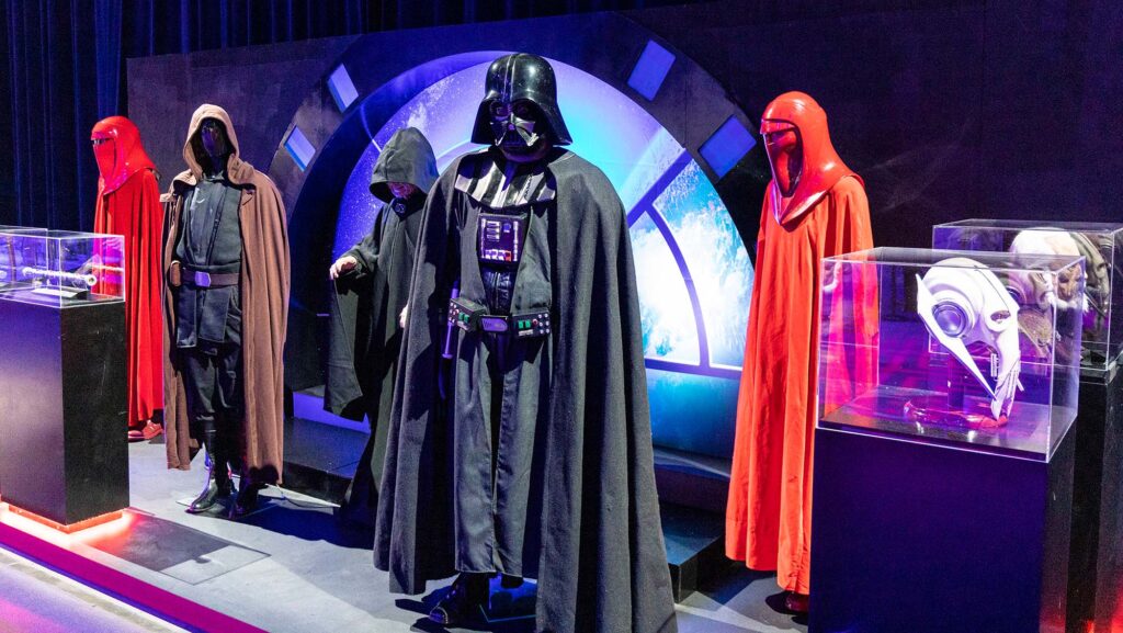 A Darth Vader and other Star Wars costumes on view in a museum exhibit