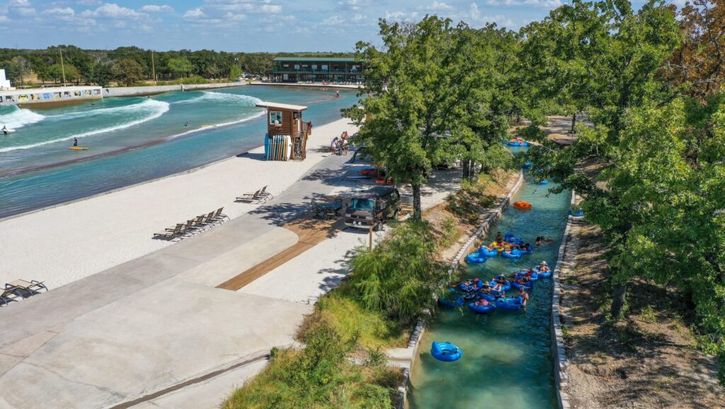 People floating in a river and surfing on a manmade wave at Waco Surf