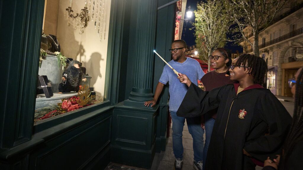 Keluarga melakukan mantra interaktif dalam dunia penyihir Harry Potter di Epic Universe