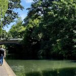 family walking along a London canal in summer on a sunny day