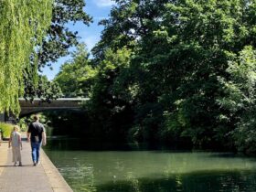 family walking along a London canal in summer on a sunny day