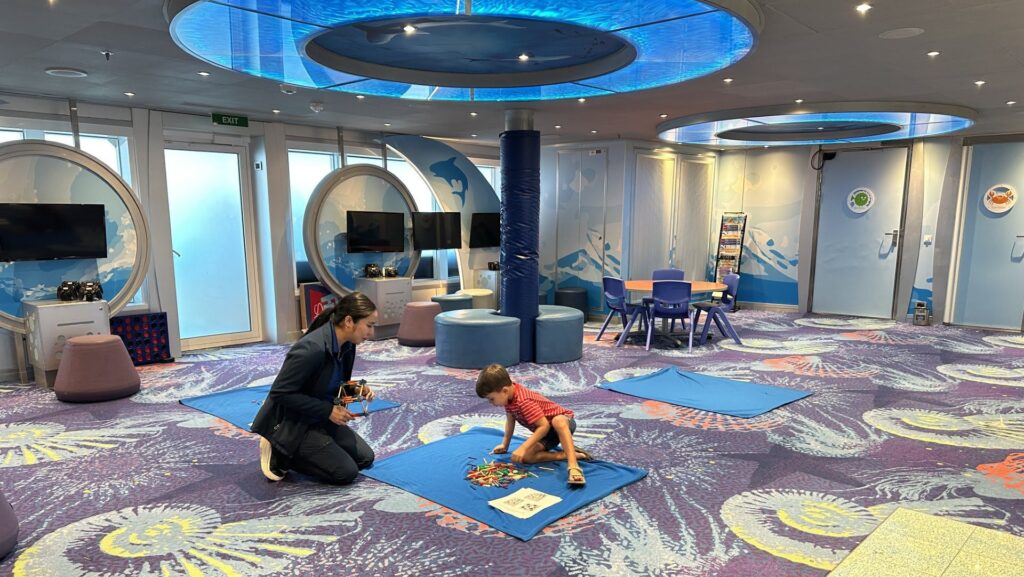 parent and child with autism doing a quiet family time activity at a kids club on a cruise