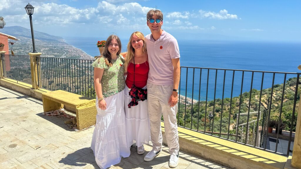 Three teenagers posing at a scenic overlook on the island of Sicily