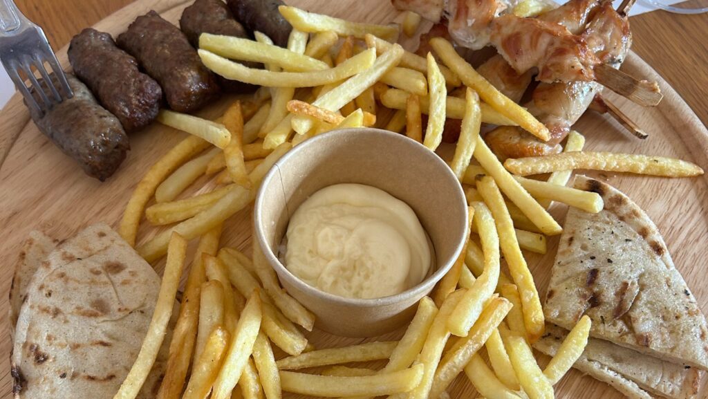 A platter of grilled meats, pita, and French fries from a Greek restaurant on Santorini