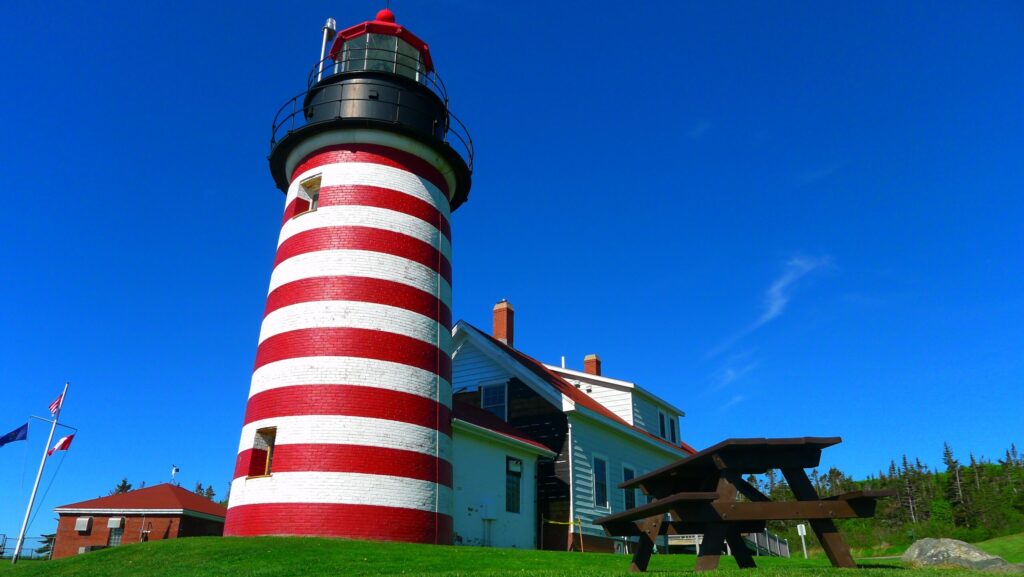 A red-and-white-striped lighthouse at Quoddy Head State Park in Lubec, Maine