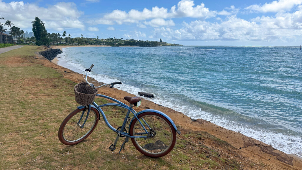 A blue bike in front of the ocean on the paved trail in Kapaa, Hawaii