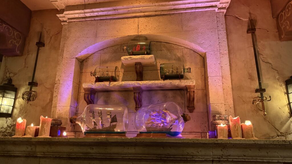 Ships in a bottle sitting on a mantle inside The Beak and Barrel