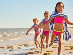 Three kids running on the beach at Ocean Edge Resort & Golf Club