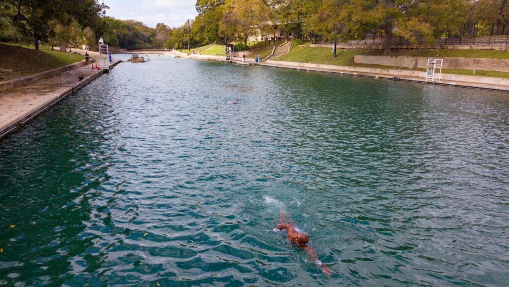 Person swimming in Barton Springs on a quiet day in shoulder season
