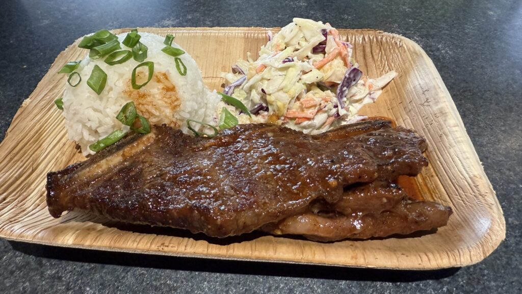 English-cut ribs on a plate with cole slaw and rice