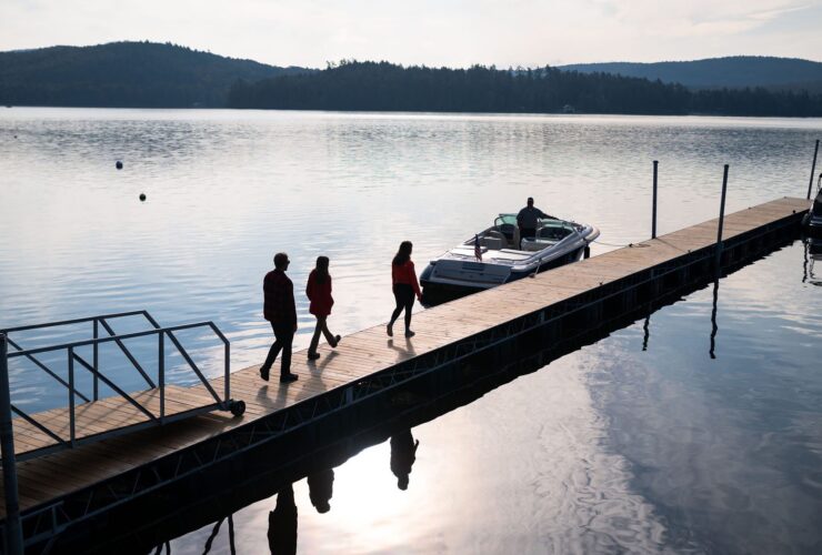 people walking along a dock toward a waiting boat at the Lodge at Schroon Lake during the quiet shoulder season