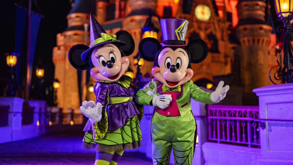 Mickey and Minnie Mouse standing in front of Cinderella Castle at Mickey's Not-So-Scary Halloween Party