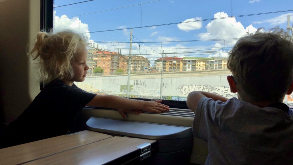 children looking out a train window in Europe