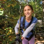A girl ziplining in the woods in Williamsburg, VA