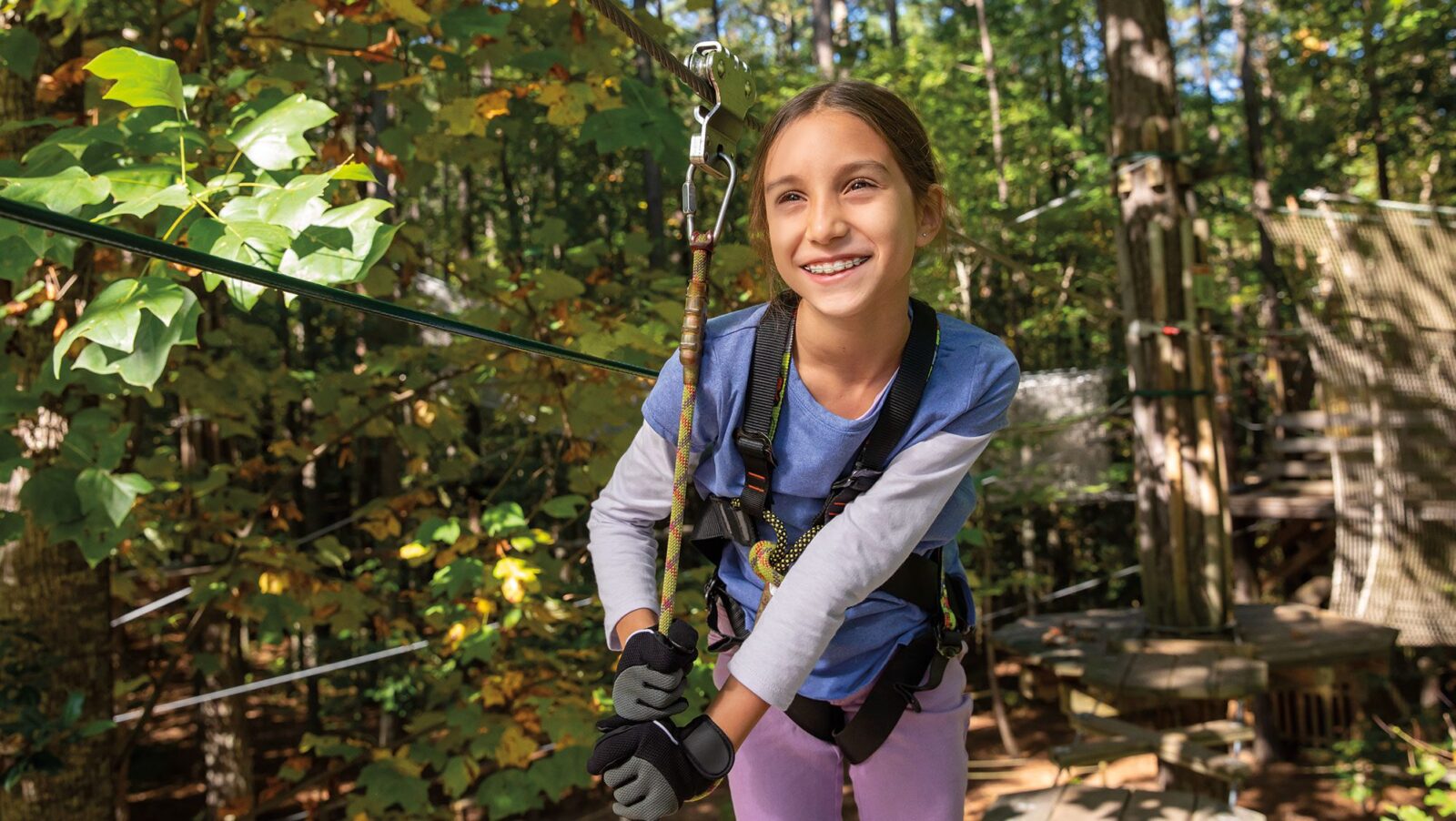 A girl ziplining in the woods in Williamsburg, VA