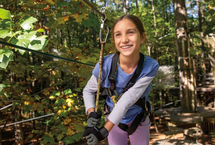 A girl ziplining in the woods in Williamsburg, VA