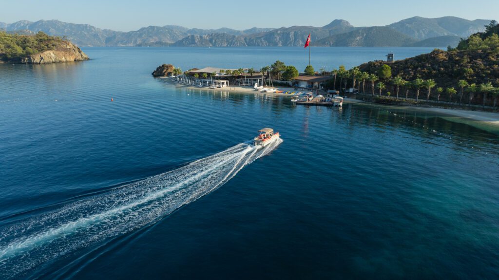 A boat plying through the water toward the marina at D Maris Bay