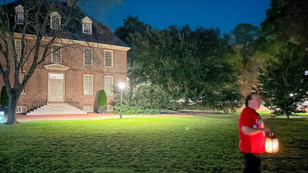 A man holding a lantern leading a ghost tour in Williamsburg, VA