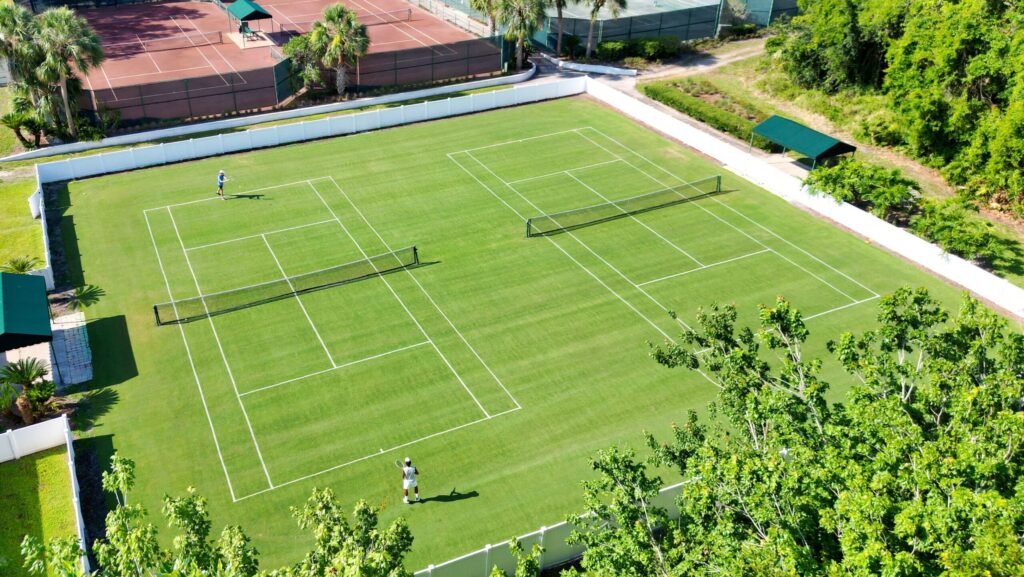 Two people playing tennis on a grass court at Saddlebrook Resort