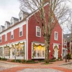 A red building on a cobblestone street decorated for Christmas in Nantucket, MA